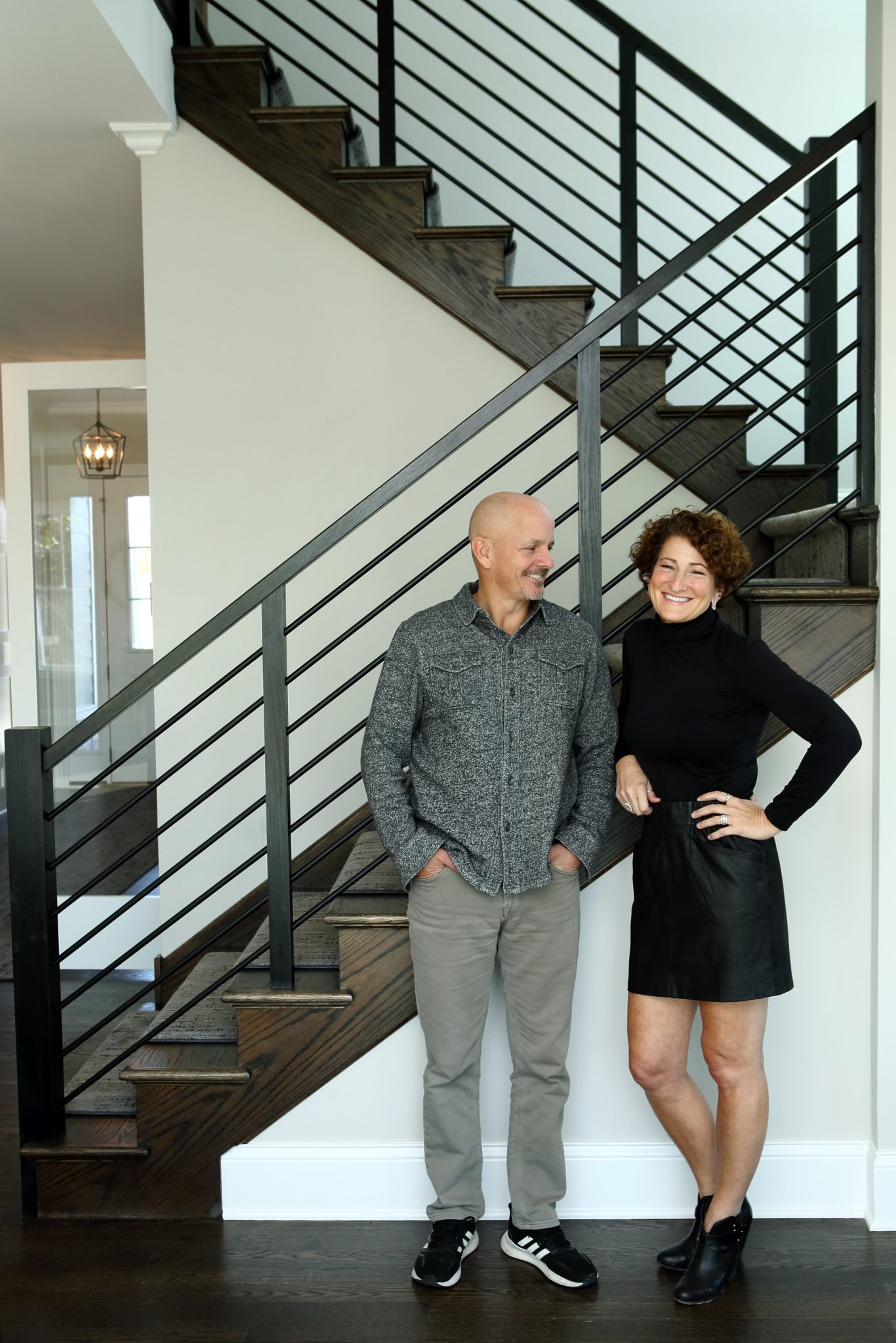 Charlie and Jenny at the foot of a staircase in a home Icon remodeled